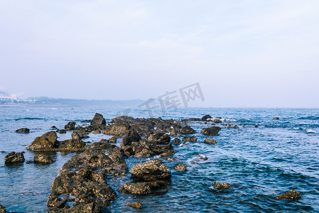 大海礁石摄影照片_秦皇岛白天大海礁石拍岸摄影图配图