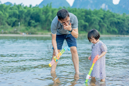 清新亲子摄影照片_亲子玩水夏季父女河边玩水摄影图配图