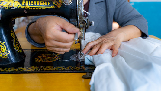 缝制衣物八十年代裁缝师缝纫机缝合布料摄影图配图