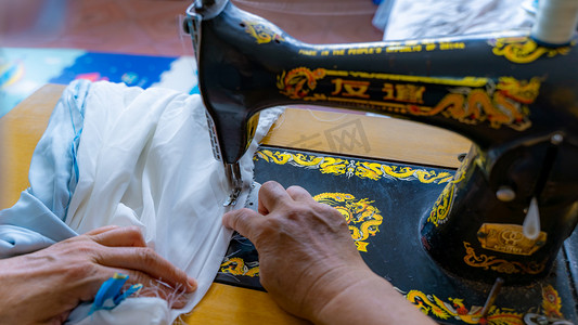 传统制衣八十年代裁缝师缝纫机缝制衣服摄影图配图