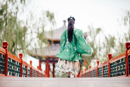 摄影照片_汉服美女白天汉服美女颐和园奔跑的背影摄影图配图