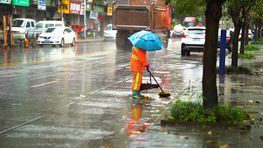 实拍下雨天大雨中扫落叶的环卫工人
