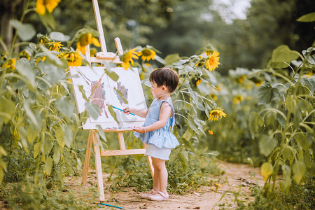 艺术启蒙摄影照片_儿童白天夏天可爱小女孩公园里画画摄影图配图