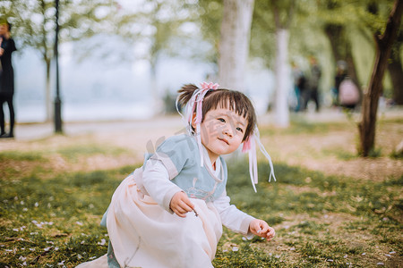 汉服儿童白天小女孩户外蹲着玩耍摄影图配图