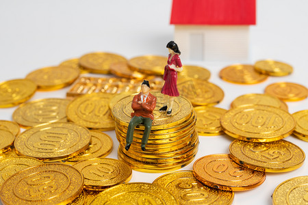 投资理财棚拍两个微距小人金币堆模型房子坐着和站着摄影图配图