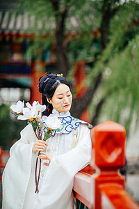 美女拿花摄影照片_汉服美女白天汉服美女户外颐和园拿着花摄影图配图