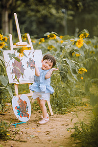 儿童画画白天画画的小女孩公园站着画画摄影图配图