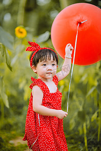 夏令营暑假摄影照片_儿童户外白天小女孩户外公园手拿气球摄影图配图