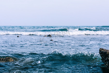 青岛海边摄影照片_青岛白天大海浪花打岸摄影图配图