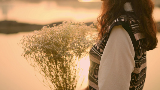 夕阳下手捧鲜花女孩剪影唯美