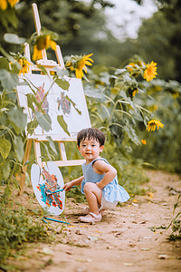 儿童户外夏天白天画画的可爱小女孩公园蹲着玩耍摄影图配图