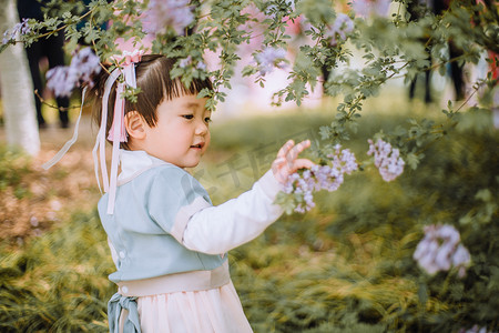 春游汉服小女孩白天可爱小女孩户外丁香花摘花摄影图配图