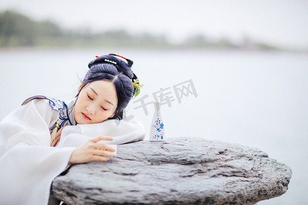 中国汉服摄影照片_汉服美女白天汉服美女石桌旁醉酒趴在桌上摄影图配图