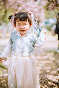 童趣摄影照片_春游汉服白天可爱小女孩樱花树下站立跑摄影图配图