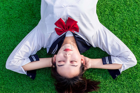 日系摄影照片_女孩白天日系少女草坪躺摄影图配图