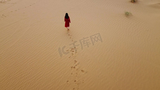 航拍女生走在荒凉沙漠中