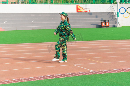 拿枪女兵摄影照片_军训早上军训女兵操场走路摄影图配图