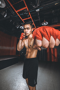健身减肥塑型夜晚练习拳击的男人健身房拳击运动摄影图配图