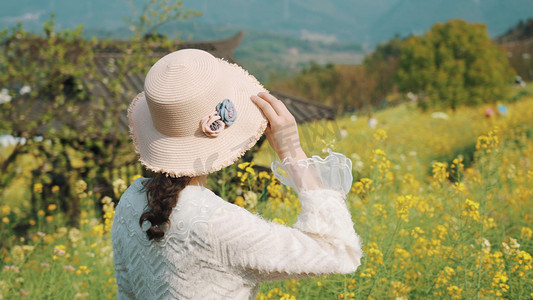 人在油菜花摄影照片_春天女生行走在花海中唯美小清新意境