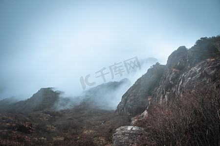 山顶云雾摄影照片_云雾缭绕的山顶下午山峰山顶无摄影图配图