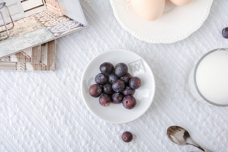 蓝莓甜品摄影照片_美食早晨蓝莓白色蕾丝桌布上摆放摄影图配图