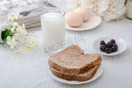 面包店新开业摄影照片_美食早晨全麦面包桌子上摆放摄影图配图