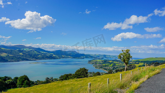 草地蓝天摄影照片_新西兰下午海景天云海俯瞰风景摄影图配图