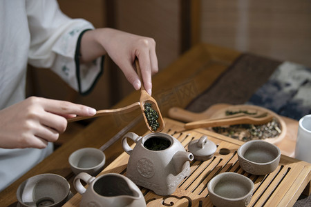 弘扬中国传统文化摄影照片_茶道傍晚女性在茶室泡茶摄影图配图