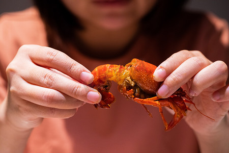 美食摄影照片_麻辣小龙虾夜晚吃虾的人餐桌扒虾摄影图配图