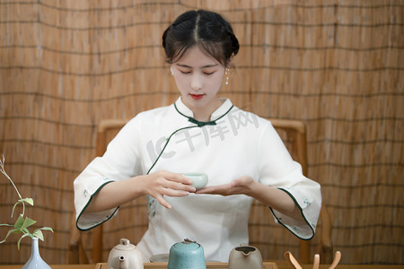 茶文化节白天女性在茶室端着茶杯摄影图配图