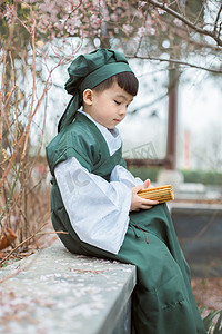 古风孩子春天男孩子公园看书摄影图配图