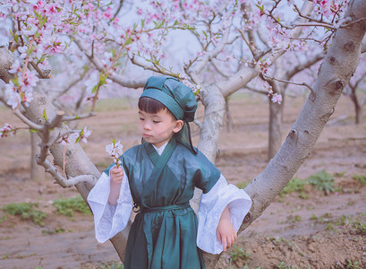 十里桃花字体摄影照片_古风人物春季孩子桃林看桃花摄影图配图