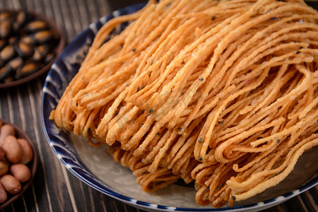 油炸食品摄影照片_美食白天馓子瓷盘里的摆放摄影图配图