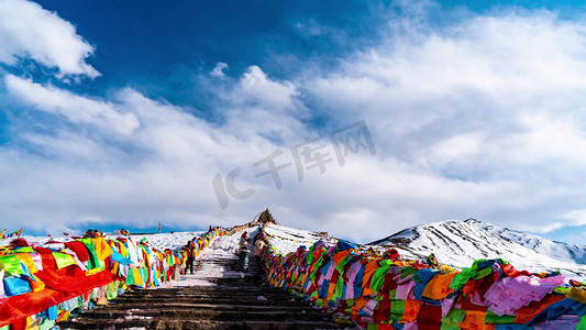 海外宣传单摄影照片_西藏著名景点折多山彩旗飘扬登山人流