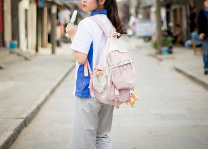 马尾女孩摄影照片_上学街道学生马尾青春摄影图配图