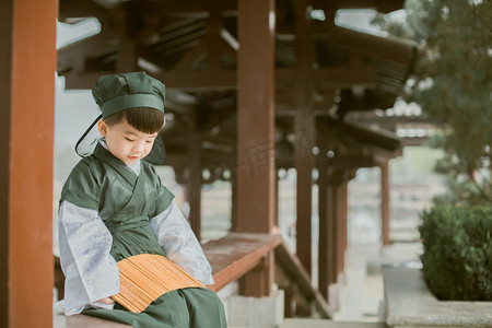 古风亭子摄影照片_古风儿童春天白天男童凉亭看竹简摄影图配图