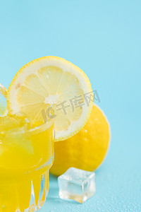 夏季柠檬汁摄影照片_柠檬水夏日冰爽创意蓝色背景摄影图配图
