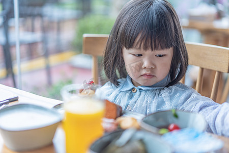 萌萌哒小孩摄影照片_早餐女孩早上上午娃娃三岁餐厅吃早餐半身摄影图配图