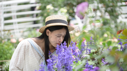 美丽的少女在花丛中闻花香