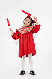 儿童节节日祝福摄影照片_喜庆早上祝福的儿童室内糖葫芦摄影图配图