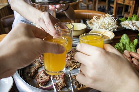 火锅饮料摄影照片_聚会白天碰杯烤肉馆美食实拍摄影图配图