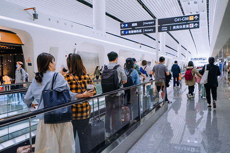 排队等电梯摄影照片_出行方式白天去坐飞机的乘客机场内部乘电梯摄影图配图