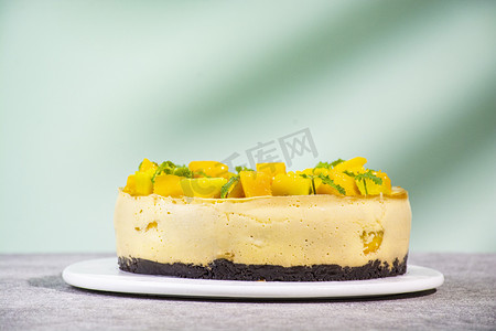 慕斯蛋糕蛋糕摄影照片_餐桌上的芒果慕斯蛋糕下午芒果慕斯蛋糕室内静物摄影图配图