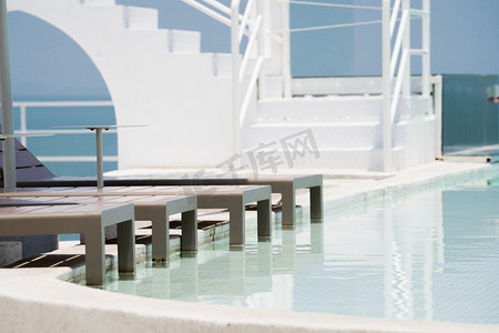 海边酒店摄影照片_度假酒店白天泳池空镜游泳池空镜摄影图配图