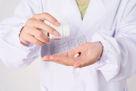 医疗医生拿着药瓶往手上倒药丸摄影图配图