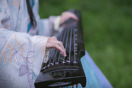 女孩摄影照片_弹琴的古风女子下午女孩草地弹琴摄影图配图