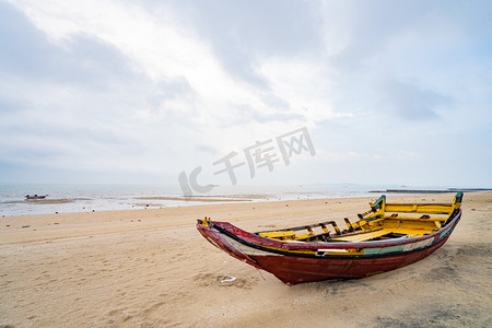 旅游杂志画册摄影照片_海岛傍晚停在沙滩的木船户外海滩空镜摄影图配图