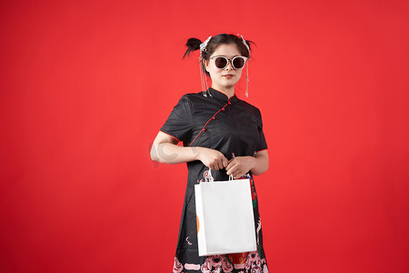 新中国风国潮摄影照片_国潮旗袍中国风女子戴着墨镜购物摄影图配图