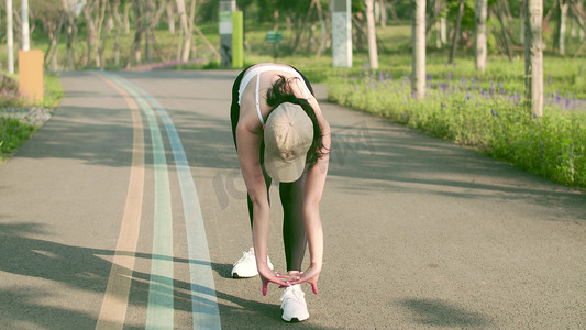 运动会书法摄影照片_实拍晨练美女跑步前热身拉伸运动