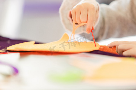 手工白天做手工的手户外穿针引线摄影图配图